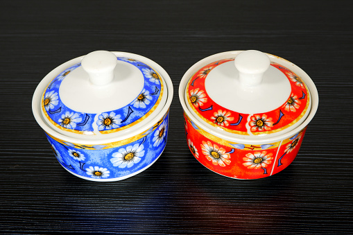 Traditional floral pattern ceramic jars together isolated on dark background close-up view