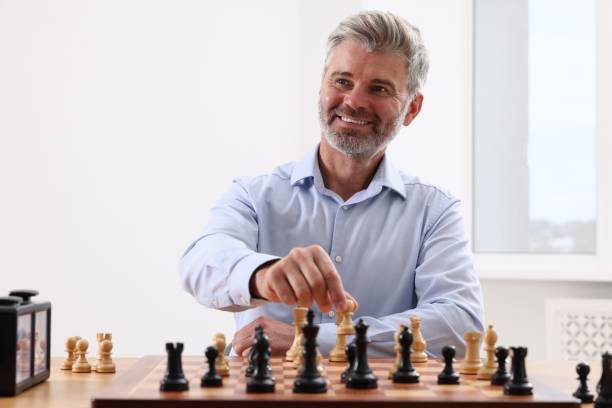 istock Happy man playing chess during tournament at table indoors 1901254600