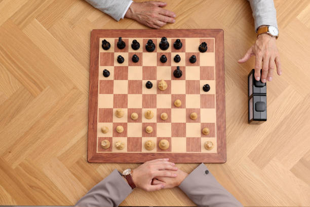 istock Player turning on chess clock during tournament at wooden table, top view 1901259199