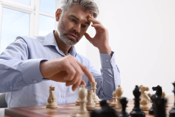 istock Man playing chess during tournament at chessboard indoors 1901264307
