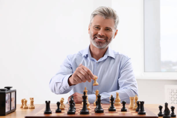 istock Happy man playing chess during tournament at table indoors 1901264812