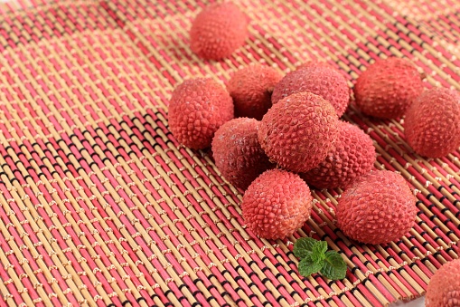 Litchi, Lichee, Lychee, or Lichi, Fresh Lychess Fruit on Pink Bamboo Background