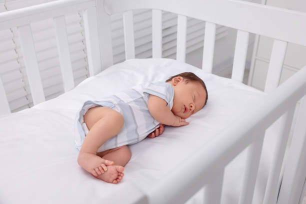 istock Cute newborn baby sleeping in crib. Bedtime 1901381747