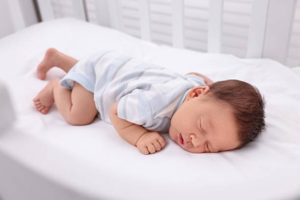 istock Cute newborn baby sleeping in crib. Bedtime 1901381748