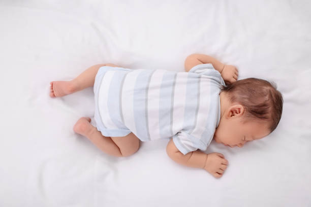 istock Cute newborn baby sleeping on white soft bed, top view 1901382259