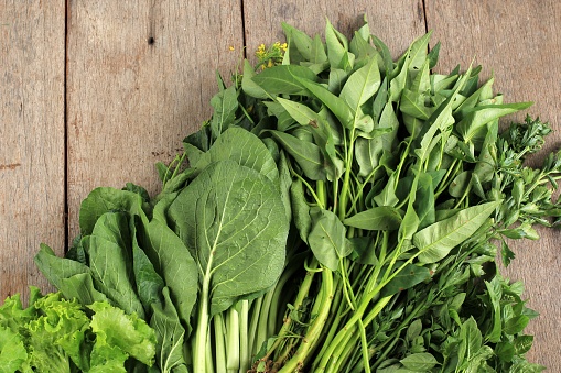 Healthy Food, Various fresh  Vegetables Leaf On a Brown Marble Wooden Background. Top View. Copy Space. Leetuce, Kangkung (Morning Glory), Celery, Sweet Basil