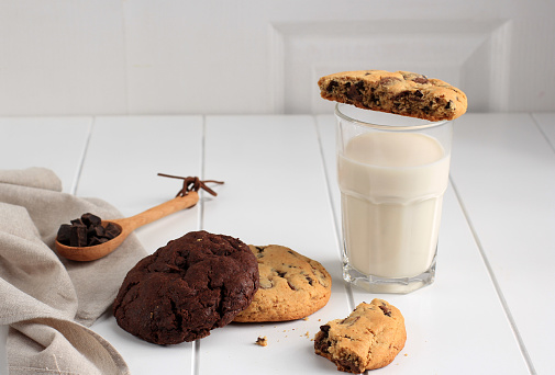 Soft and Chewy Chocolate Chip Cookies on White Table. Closeup Chocolate Chip Cookie Topping with Milk. Homemade Baked Chocolate Chip Soft Cookies.
