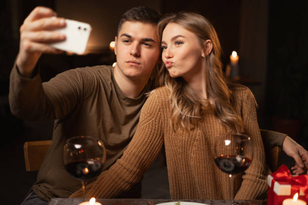 istock romantic young couple posing for selfie while having dinner at night at restaurant or home, St. Valentine's Day concept 1901435237