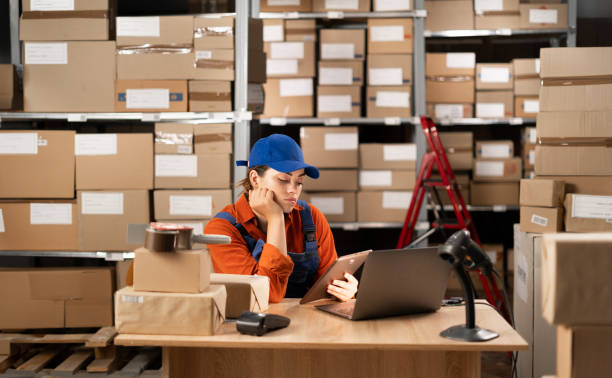 istock Bored warehouse worker working in the evening watching movies using digital tablet at workplace 1901435754
