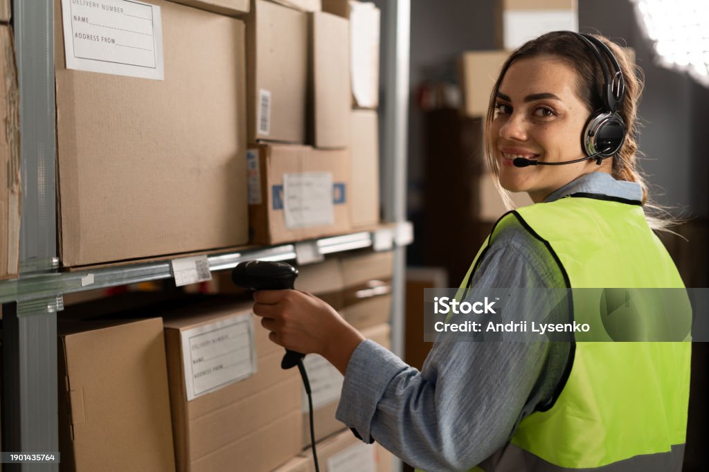 Warehouse Scanner Operator Portrait Of A Smiling Warehouse Staff Using A Headset While Working In ...