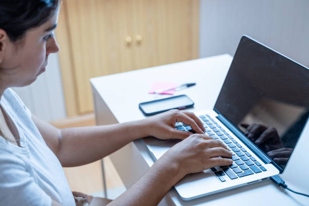 istock Young woman working on laptop computer at home office. Work from home concept. 1901436270