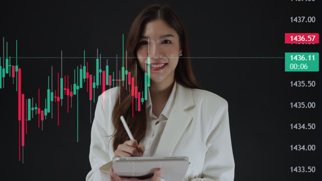 Beautiful Asian businesswoman extremely happy and glad that the stock graph is green.