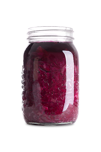 Red cabbage, homemade fermented German Blaukraut in a glass jar. Cut raw red cabbage, fermented by lactic acid bacteria. Unpasteurized and uncooked blaukraut provides probiotics and improve digestion.