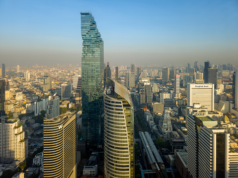 Shanghai, China - June 11th 2022: Tourists on Bund boulevard with Pudong district on background. Pudong district houses Lujiazui Finance and Trade Zone and Shanghai Stock Exchange, it is China's financial center.