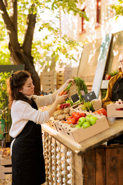 istock Vendors arranging greenmarket stall 1901502842