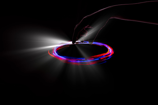 Circle of lights with silhouette of hand playing with luminous point indicator - Abstract image reflecting futuristic and cutting-edge technology.