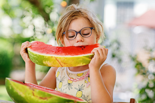 Little Girl, Preschooler, Delights in a Juicy Watermelon on a Sunny Summer Day. Child sharing a Healthy Snack with Her Family, She Embraces the Joy of Summertime Bliss.