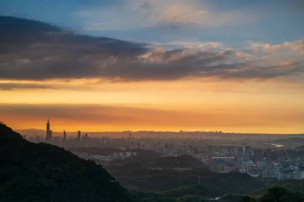 In serene sunset tones, stunning views of the Taipei skyline are highlighted by the iconic Taipei 101 tower. Xizhi Dajianshan, Taiwan.