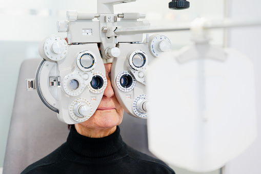 Elderly woman doing vision test in an ophthalmology clinic. Eyesight care in elderly age concept.