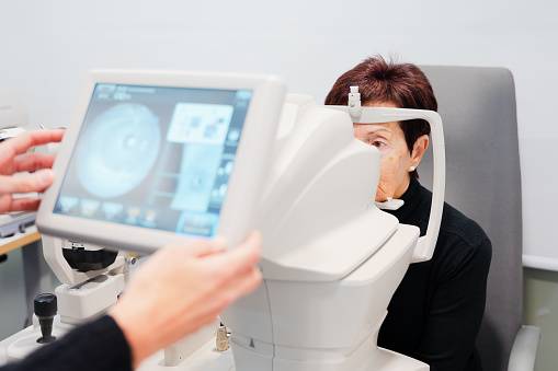 Oculist making a retinography to a patient using a modern machine