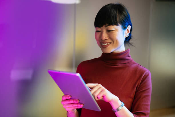 istock Asian businesswoman using technologies in modern office. Businesswoman is using digital tablet and working late in the office 1901585257