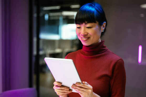 istock Asian businesswoman using technologies in modern office. Businesswoman is using digital tablet and working late in the office 1901586289