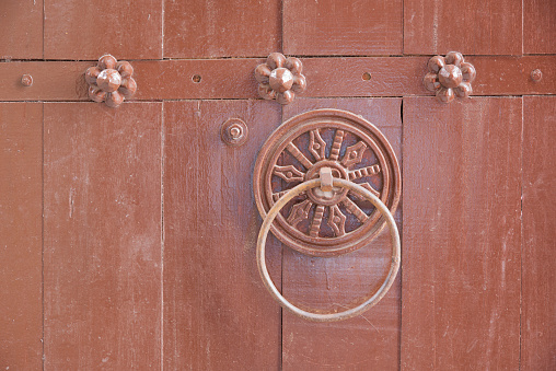 antique door handle on antique wooden door background. Backdrop. Wallpaper.