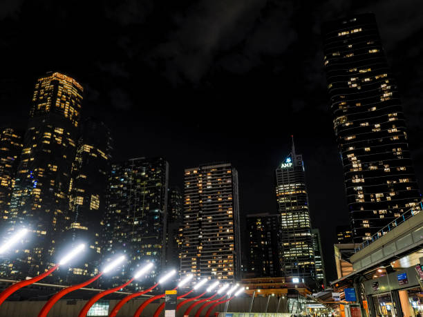 Melbourne, Australia - Aug 29, 2022: Night view of modern high-rise office buildings. Street level view from Southern Cross Bridge. Some clouds in the sky.