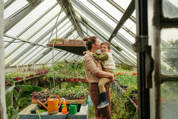 mother and son in their nursery garden - florist flower market flower store 뉴스 사진 이미지