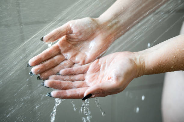 istock Close-Up of Open Hands Amidst Shower Droplets 1901634162