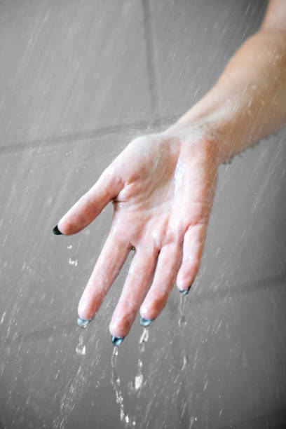 istock Close-Up of Open Hands Amidst Shower Droplets 1901635727