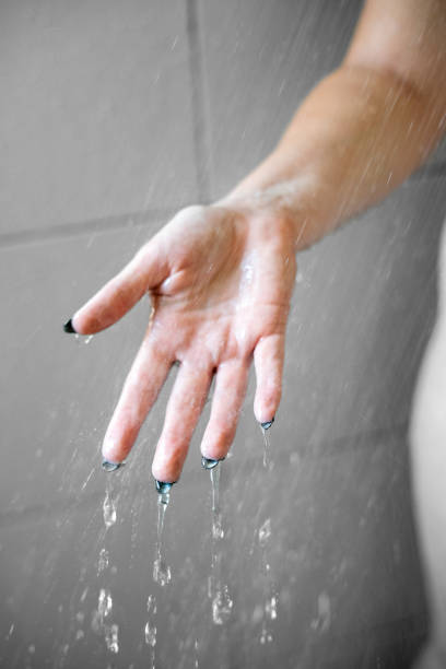istock Close-Up of Open Hands Amidst Shower Droplets 1901637294