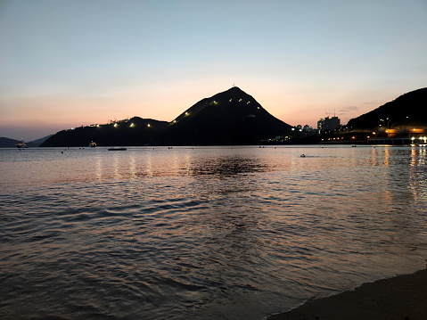 Dusk over Deep Water Bay. The bay is located on the southern shore of Hong Kong Island in Hong Kong. The bay is surrounded by Shouson Hill, Brick Hill, Violet Hill and Middle Island.