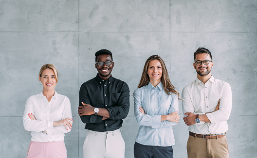 Multiracial group of creative business persons standing side by side in the office.