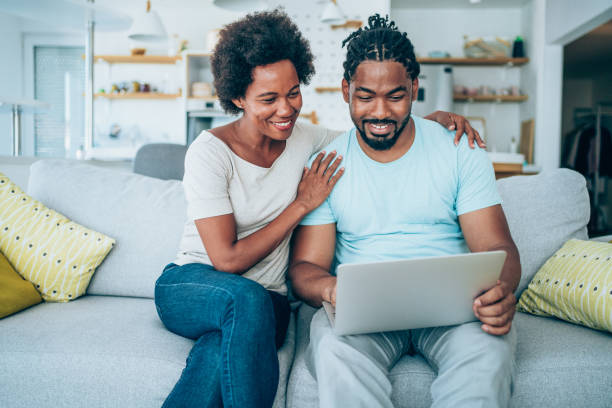 istock Couple using laptop on the sofa at home. 1901679427