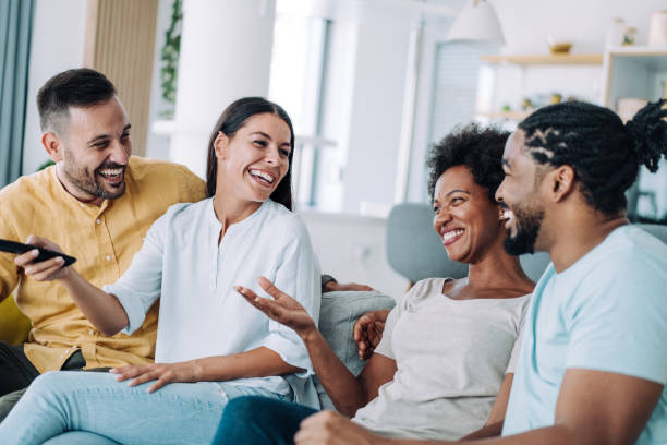 Cheerful friends watching TV at home.