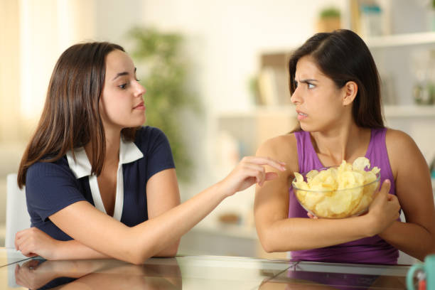 istock Woman protecting her potato chips from friend 1901685746