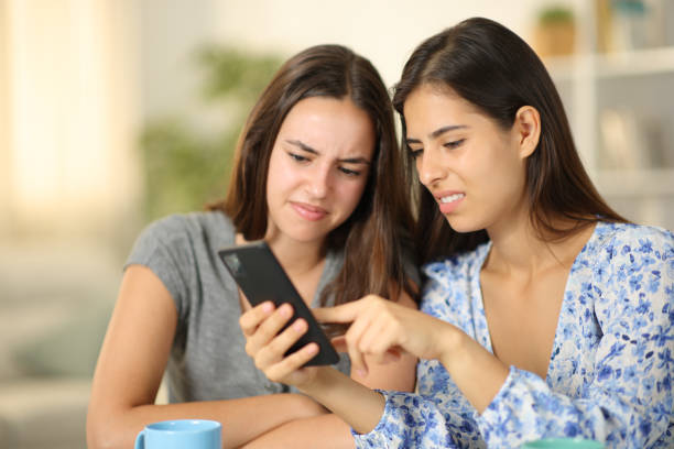 istock Disgusted friends watching media content on phone 1901688875