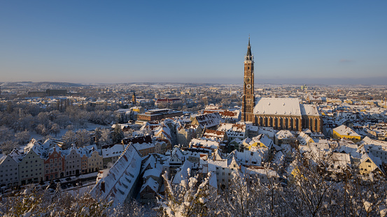 Scenic overview from Castle Trausnitz over the town Landshut, Lower Bavaria with snow covered walls and roofs in winter on sunny day