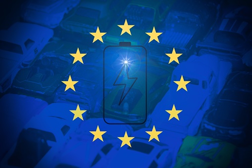 European flag with a battery illustration and cars as background. Concept of electric vehilcles in Europe.