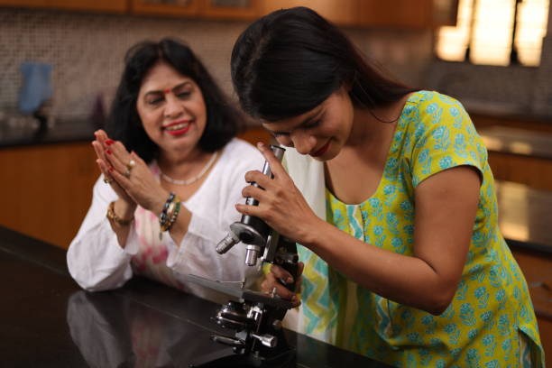istock Group of female teachers looking into the microscope in the laboratory. 1901757425