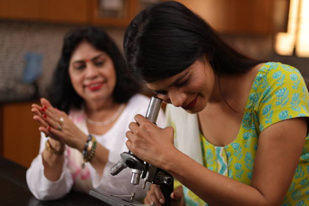 Group of female teachers looking into the microscope in the laboratory.
