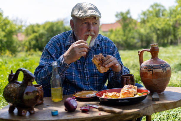 istock A farmer, an older man, is having breakfast, taking a break from mowing. 1901765160