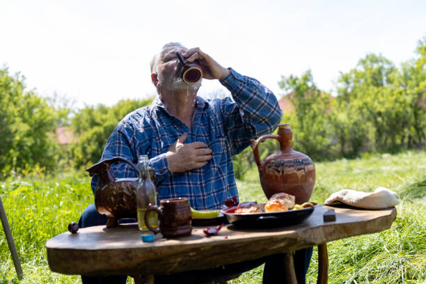 istock A farmer, an older man, is having breakfast, taking a break from mowing. 1901765273