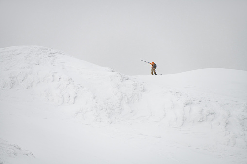 Tourist on the ridge of the Marmaros mountains. Mountains in the winter. Winter landscape of Carpathian mountains. Snow-covered hill. Ski tour concept