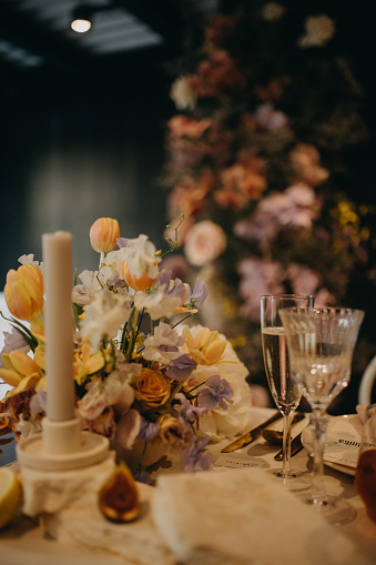 Elegant, romantic table setting for indoor spring wedding reception or party. Luxury wedding table decoration, special event table set up with fresh spring flowers arragements.