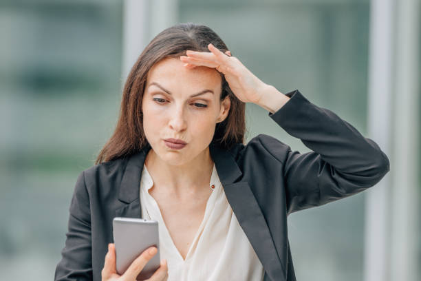 istock business woman with mobile phone and expression 1901850901