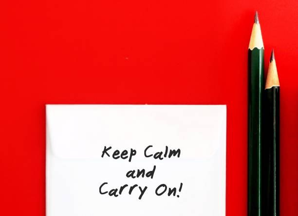 istock Pencil, Note on red copy space background with text written KEEP CALM AND CARRY ON  on blue copy space background, concept of self remind to remain calm, calling persistence in challenge situation 1901872900