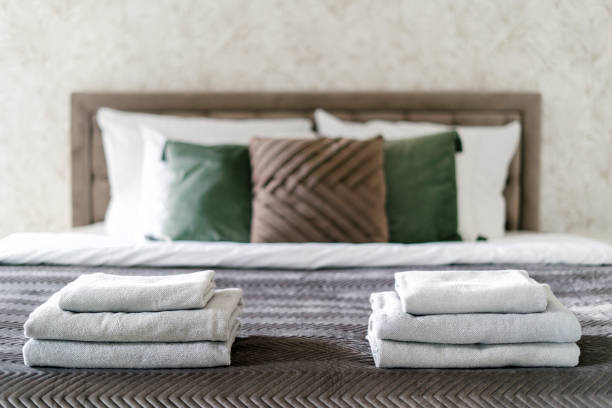 istock Clean bath towels neatly folded on comfort double bed in hotel room 1901873956