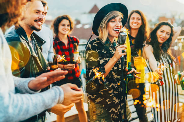 group of friends listening to live performance on rooftop party - individual event women people autumn imagens e fotografias de stock